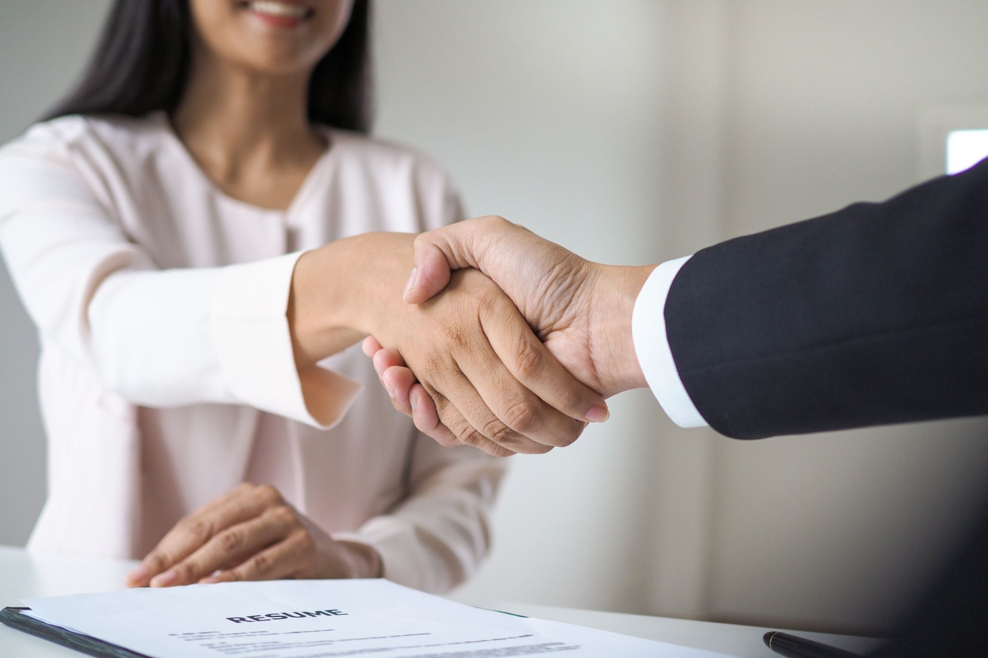 Ein Rechtsanwalt und seine Mandantin schütteln sich die Hände.