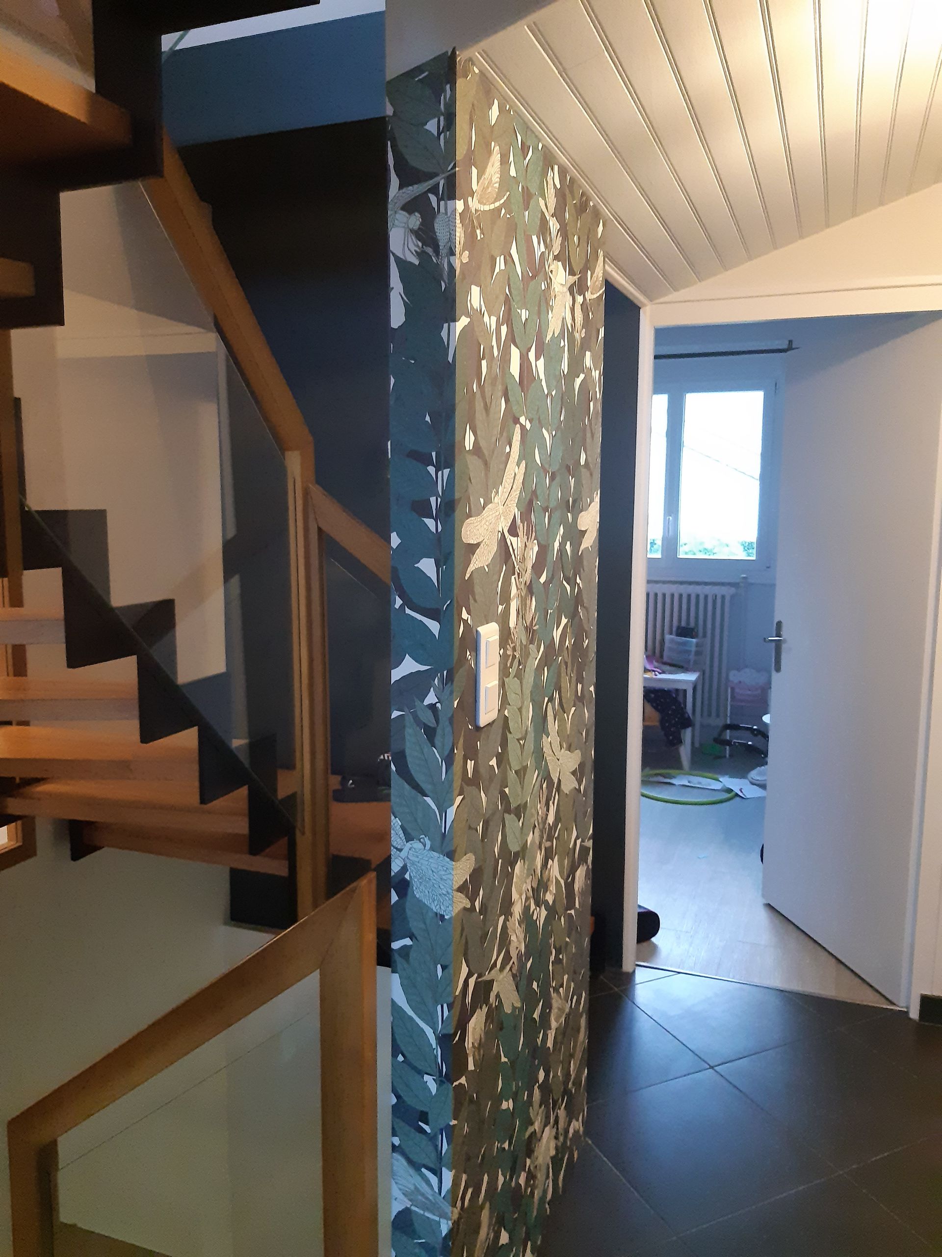 Mur séparateur entre escalier et couloir avec papier peint kaki