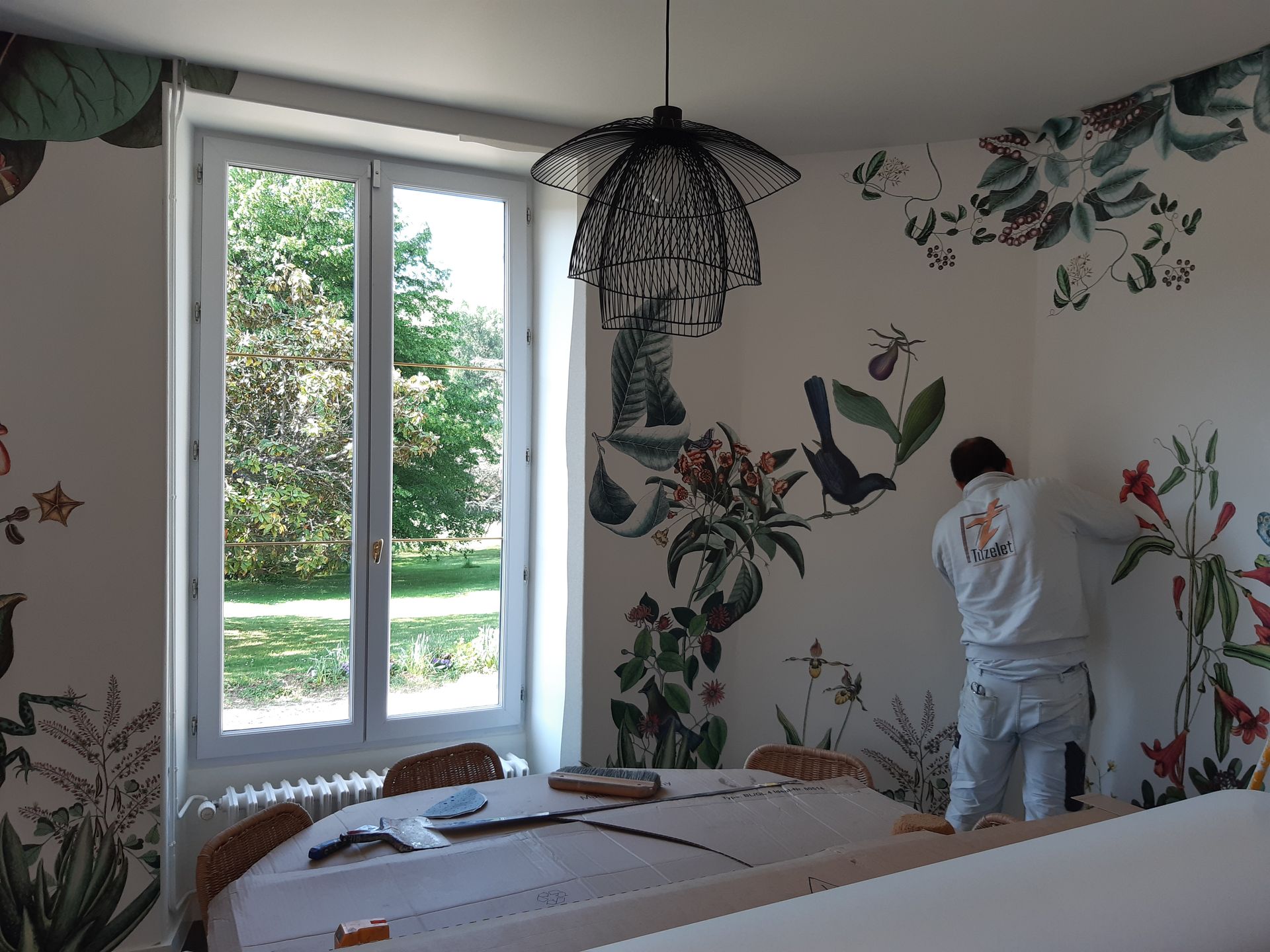 Artisan en train d'installer du papier peint