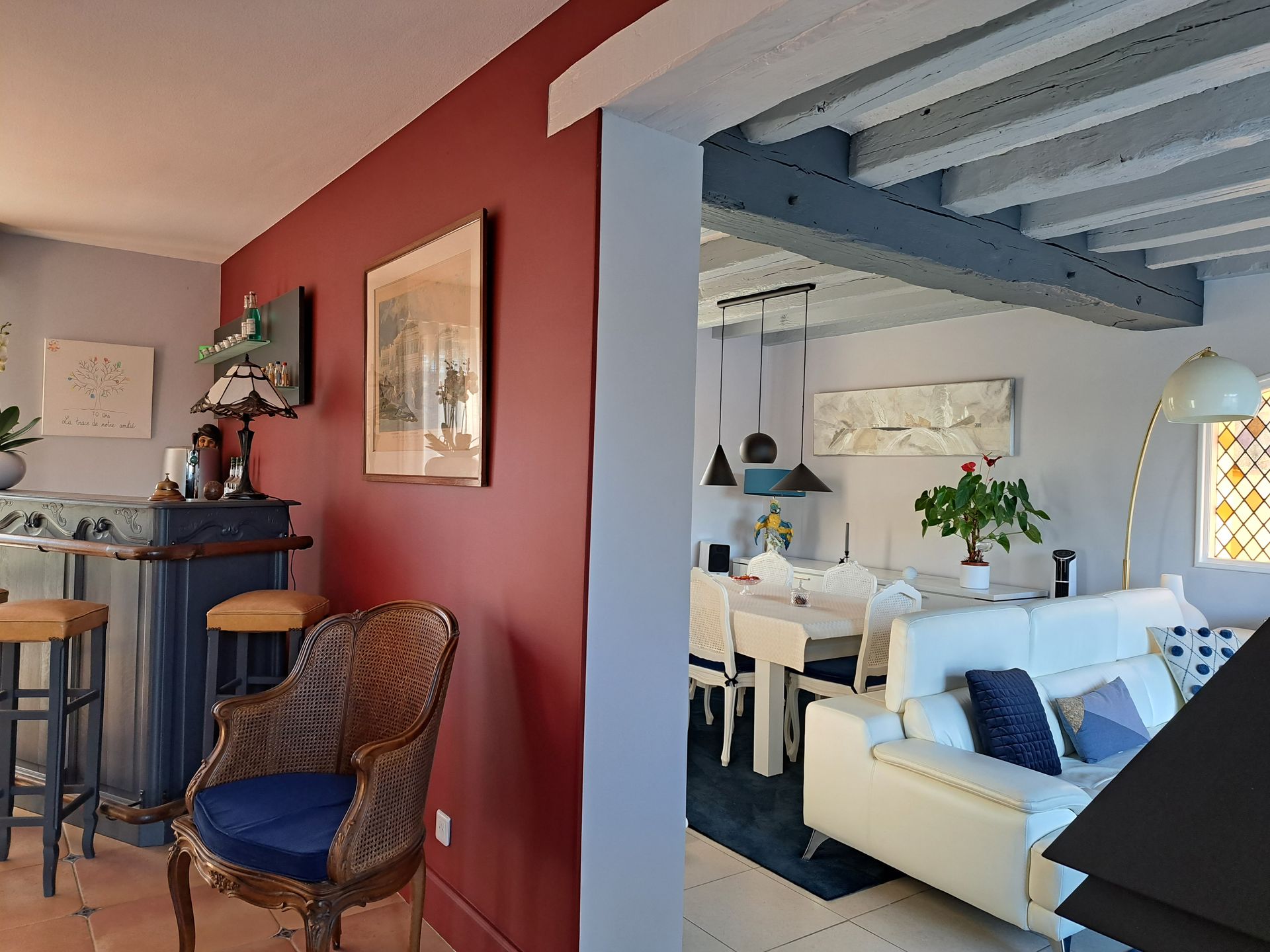 Intérieur de maison avec mur en peinture rouge et charpente apparente et repeinte