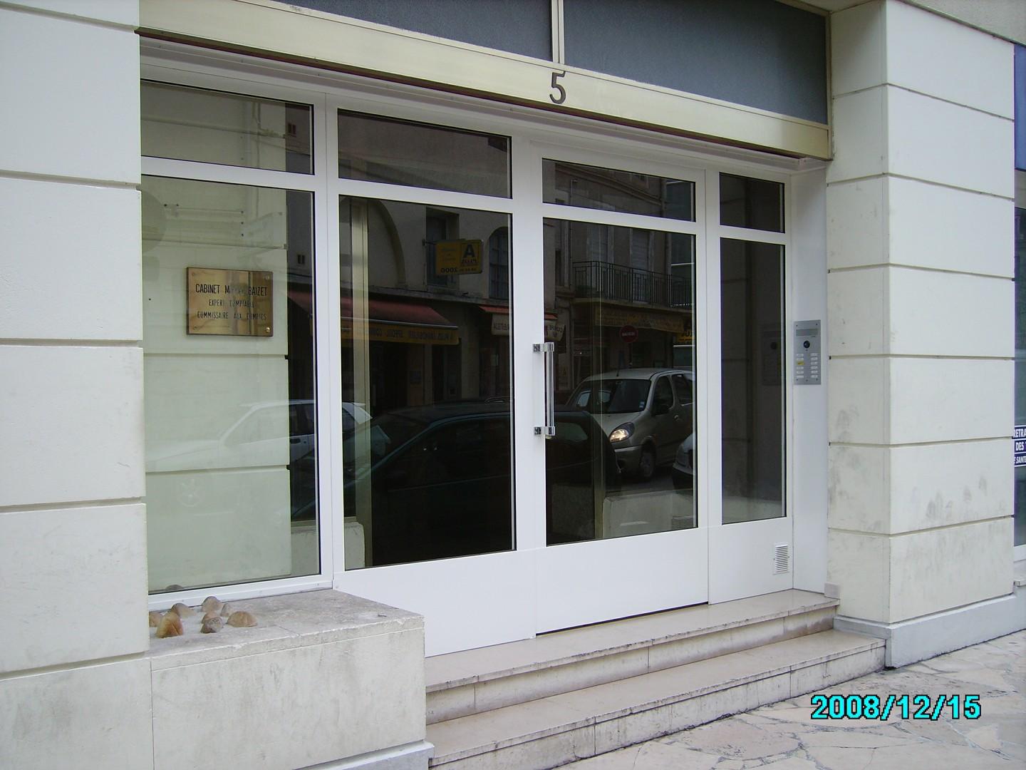 Porte d'entrée blanche avec panneaux de verre ; numéro 5 au-dessus ; extérieur du bâtiment.