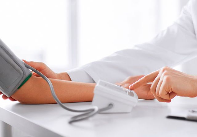 Doctor examinando las pulsaciones de un paciente