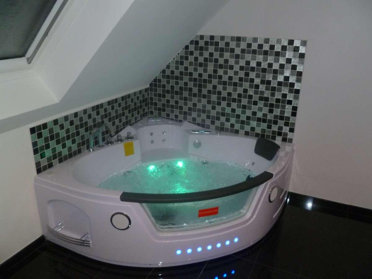 Baignoire balnéo d'angle avec effets lumineux.