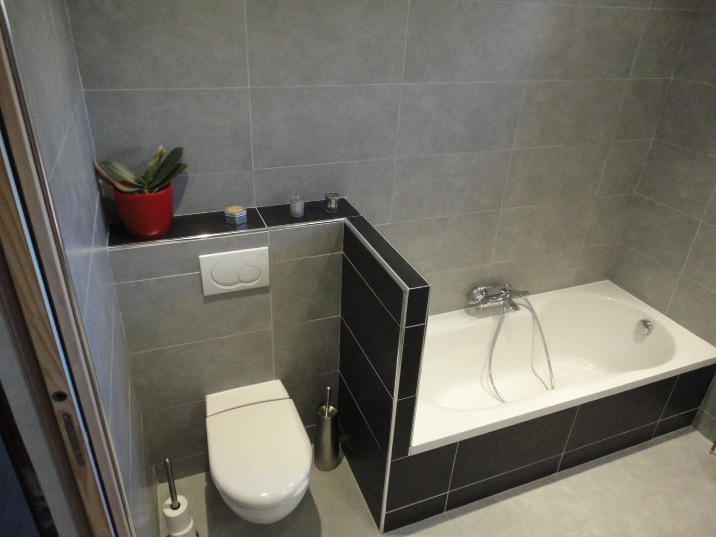 Salle de bains équipée d'une baignoire et de toilettes.