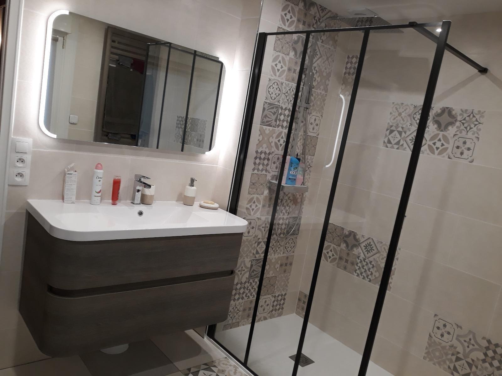 Salle de bains avec sa douche et son miroir rétroéclairé.