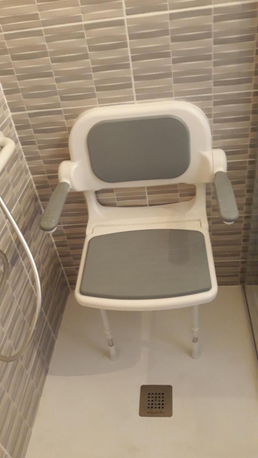 Un siège dans une douche adaptée PMR.