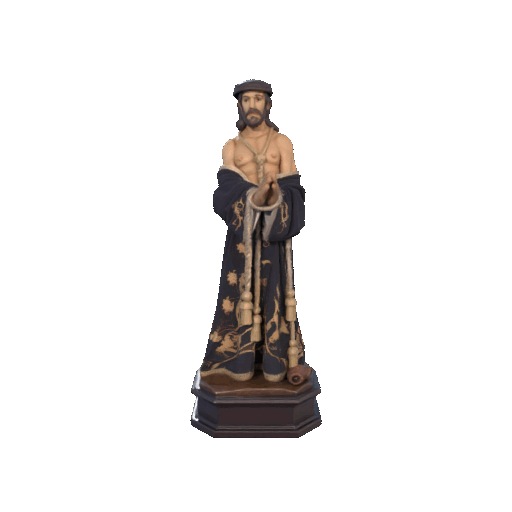 Estatua de un hombre barbudo, vestido con una túnica oscura. Está de pie con grilletes.