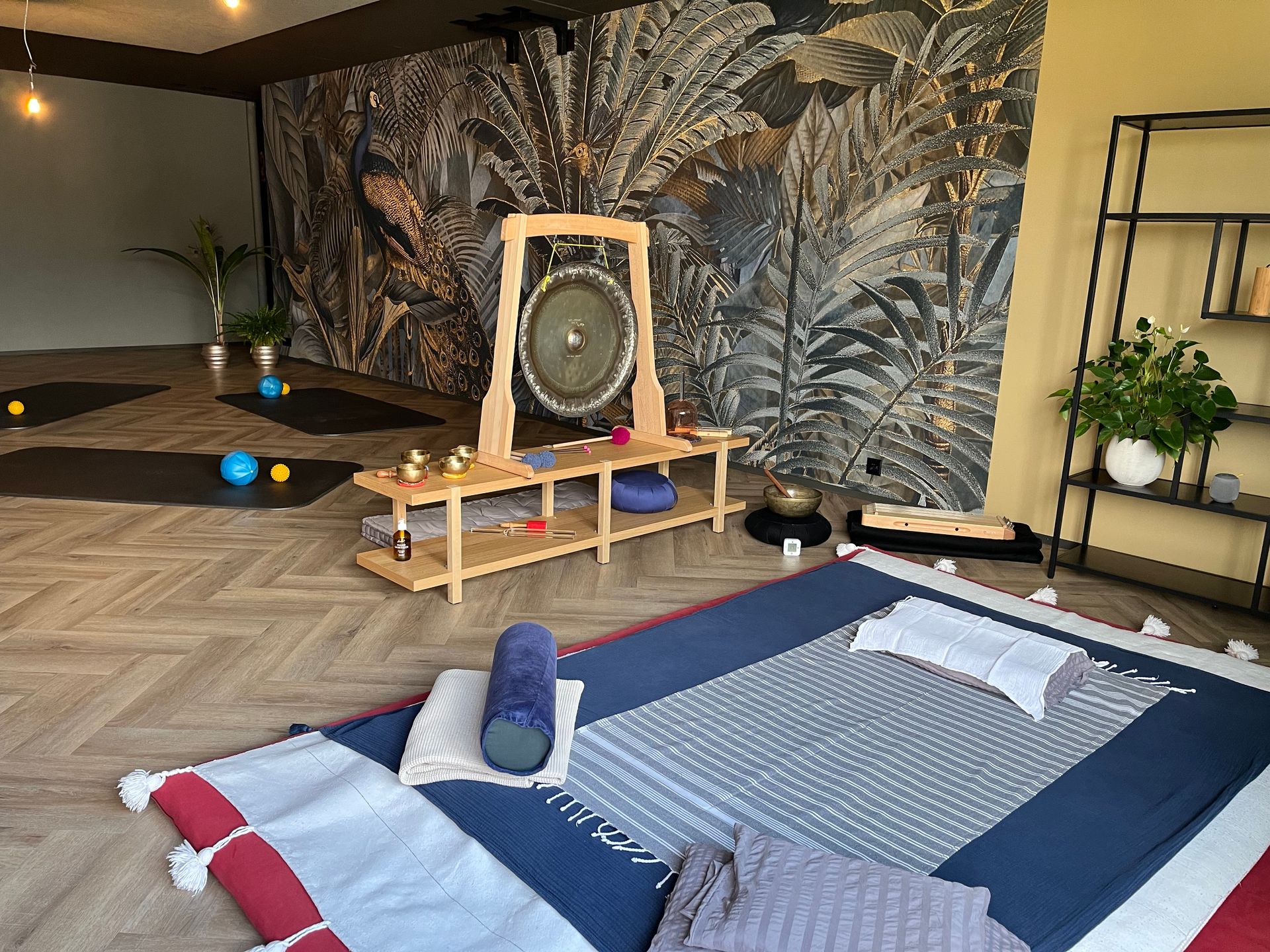 Yogastudio mit Gong, Matten und dekorativen Teppichen.