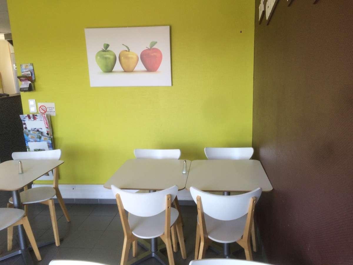 Table avec ses chaises contre un mur vert