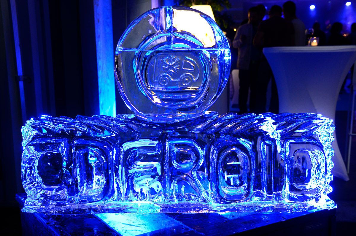Une sculpture de glace bleue formant le mot CD FROID posée sur une table lors d'un événement.