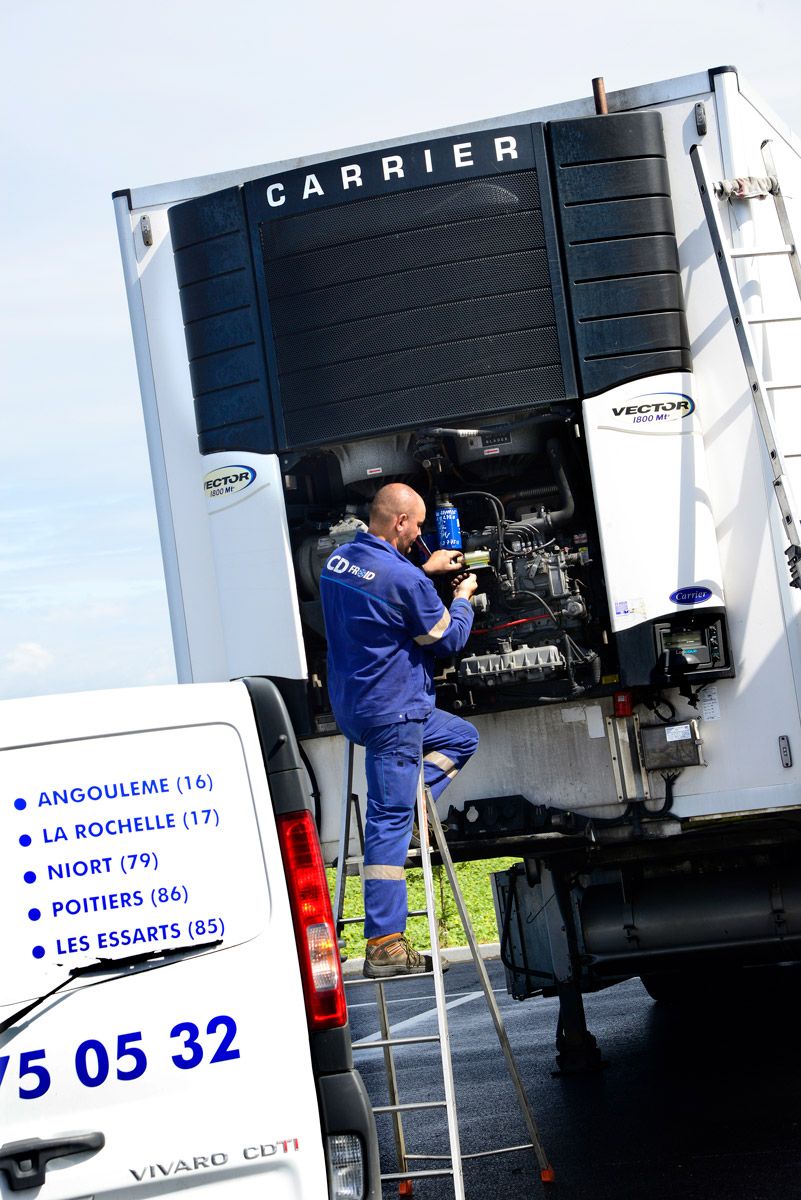 Technicien travaillant sur un groupe frigorifique Carrier ouvert, installé sur un camion, sur un site extérieur