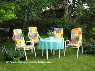 Ein Tisch und Stühle in einem Garten mit einer blauen Tischdecke