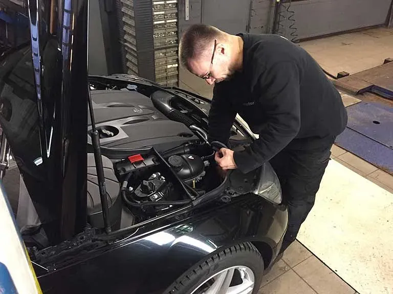 Auto nostimella Motorinin korjaamossa Turussa, huoltotyö käynnissä