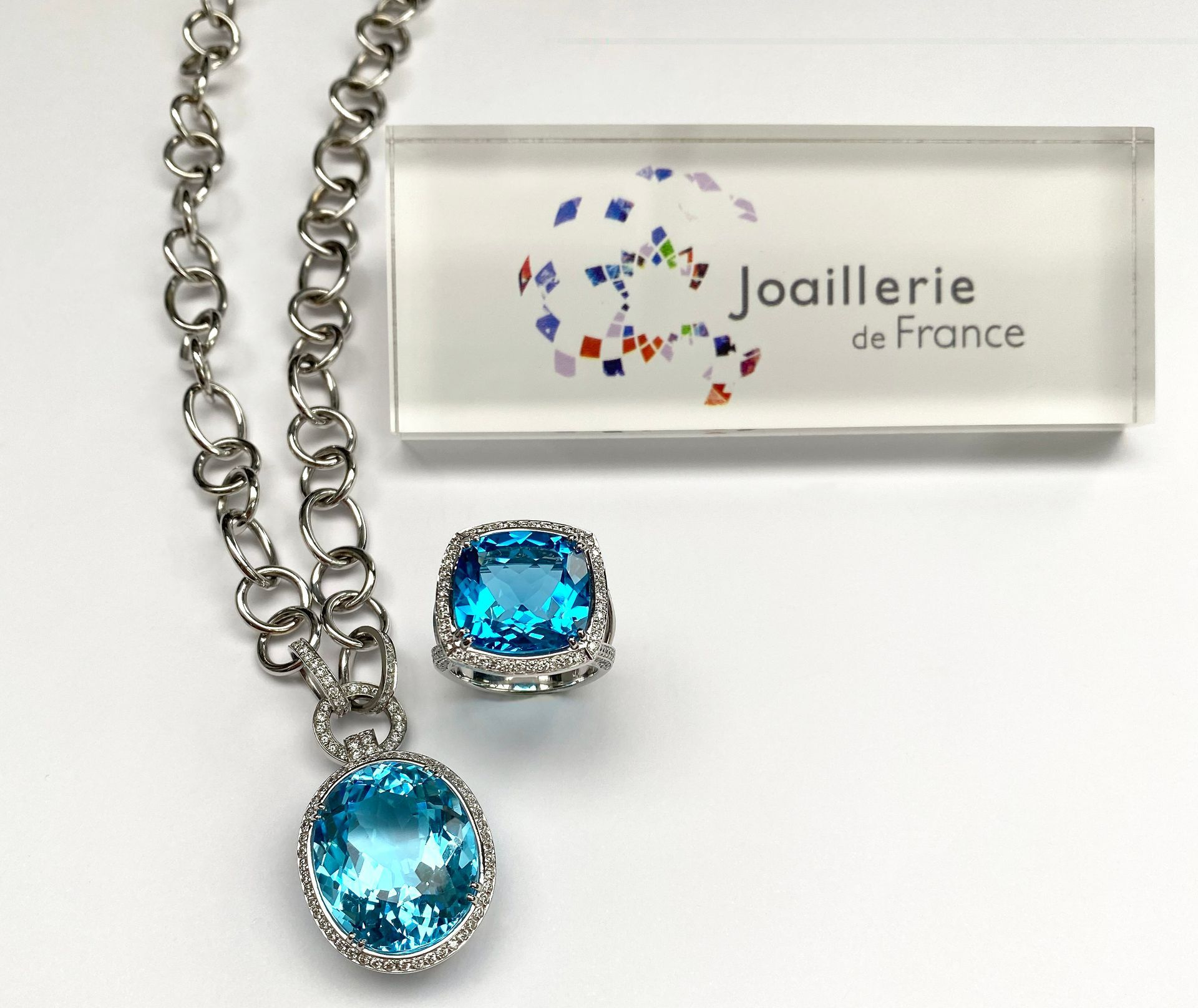 Étiquette Joaillerie de France à côté d'un collier serti d'une pierre bleue