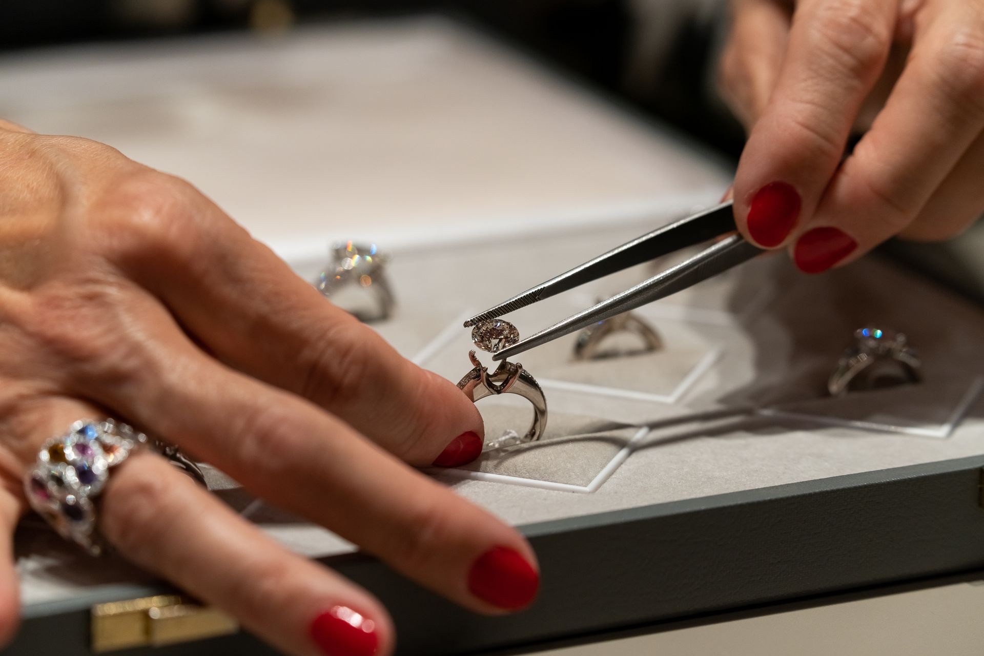Deux mains détachant un diamant d'une bague