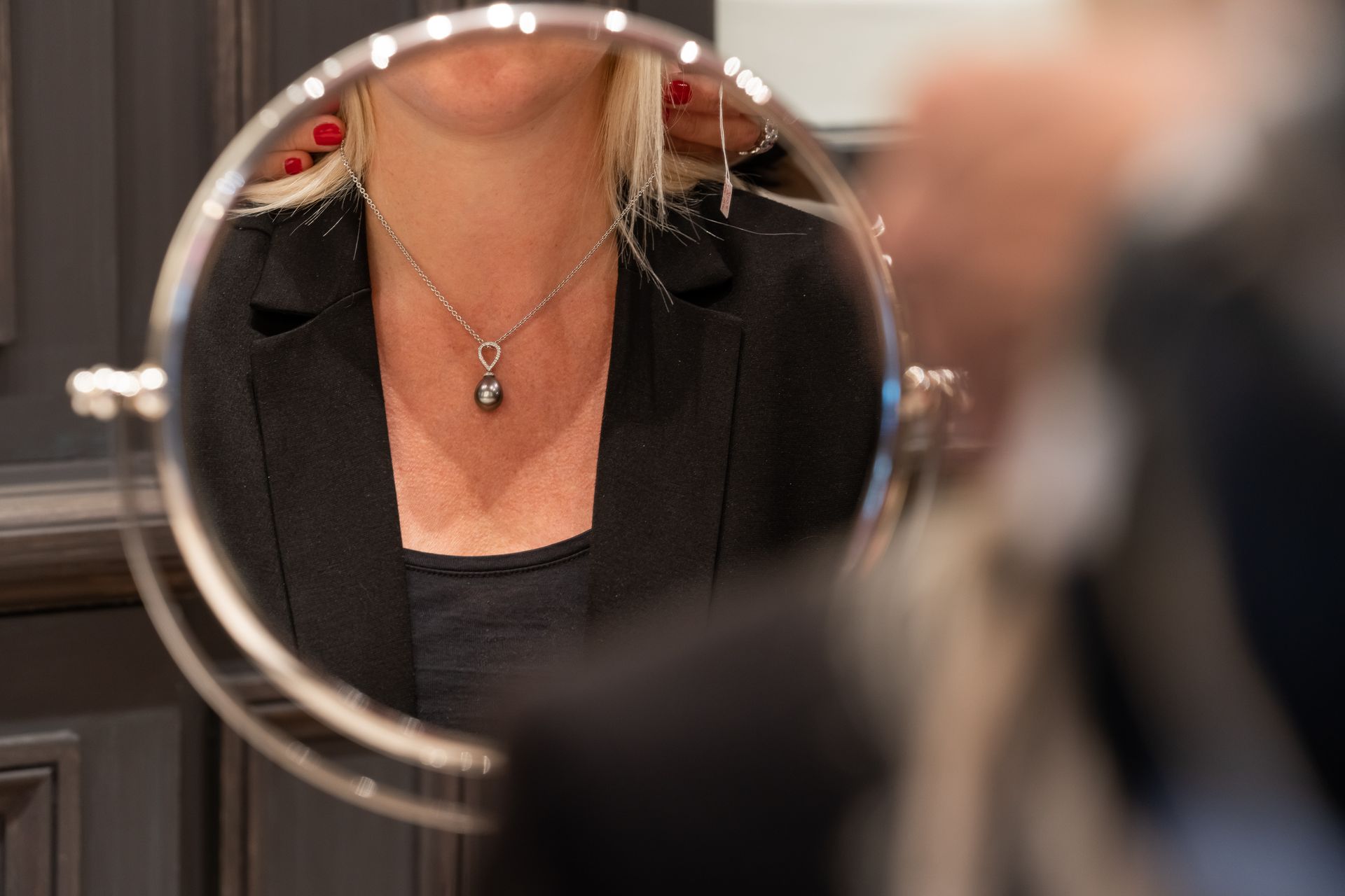 Bijoutière mettant un collier autour du coup d'une femme