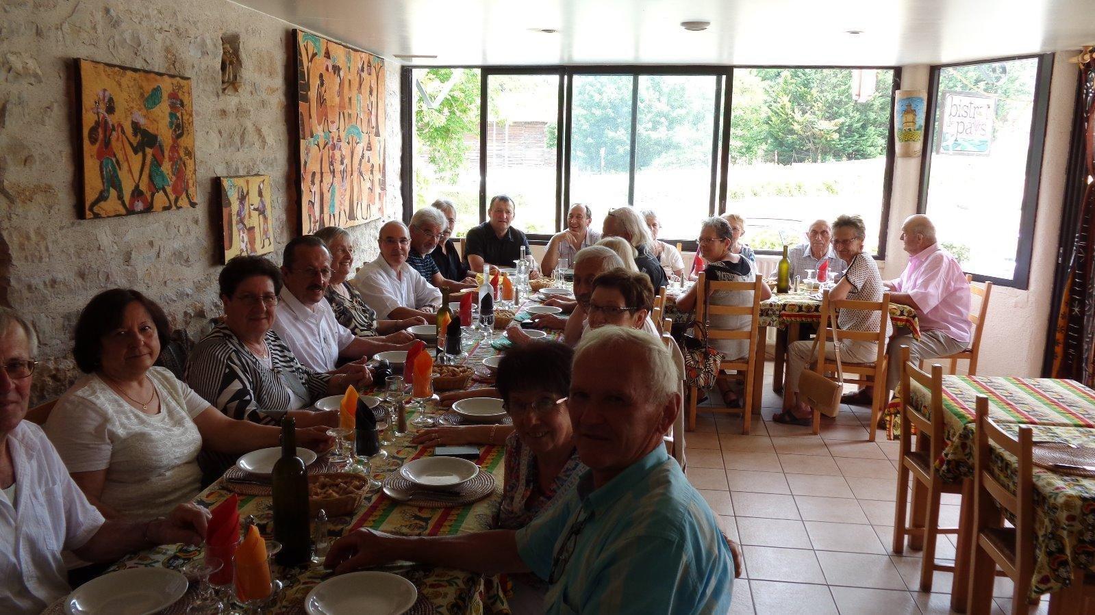 Photo de groupe de personnes en train de déjeuner dans la salle des Bastides