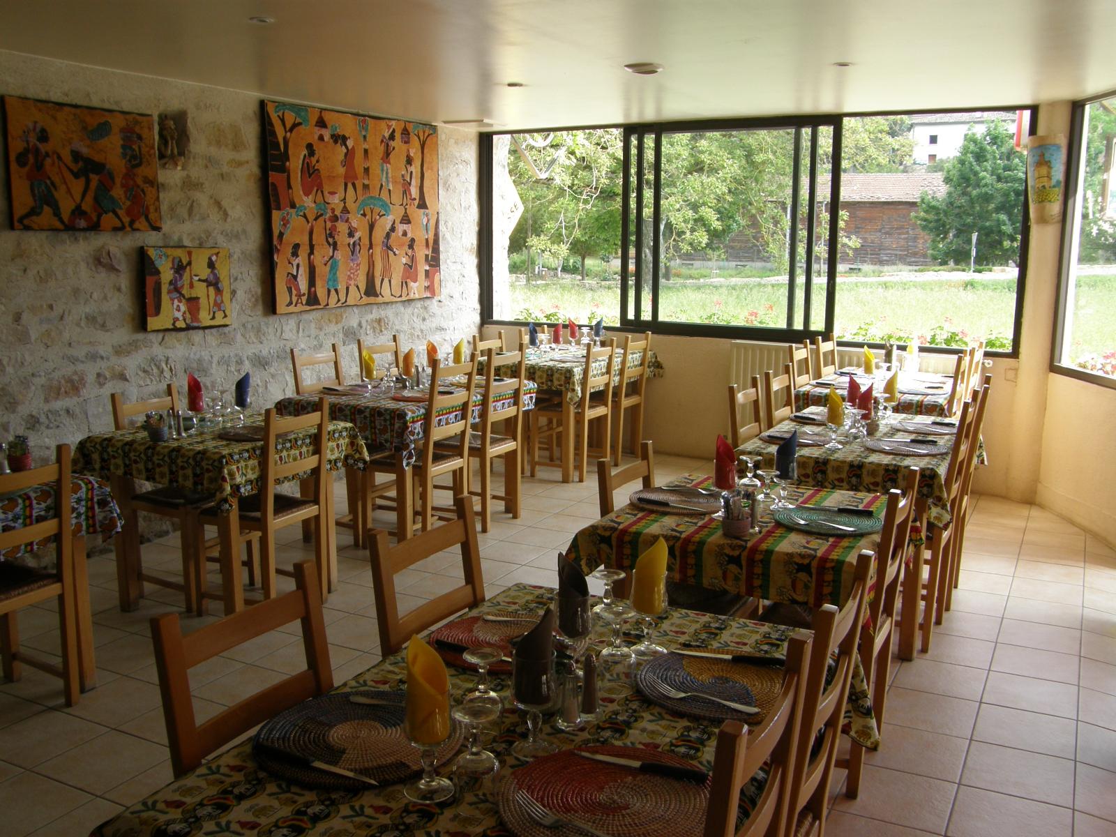 Photo de l'intérieur du restaurant Les Bastides avec tables, chaises, couverts, etc.
