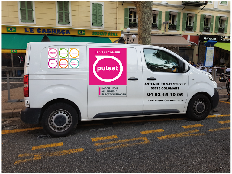 Fourgonnette blanche avec logo « Pulsat » garée dans une rue devant un immeuble.