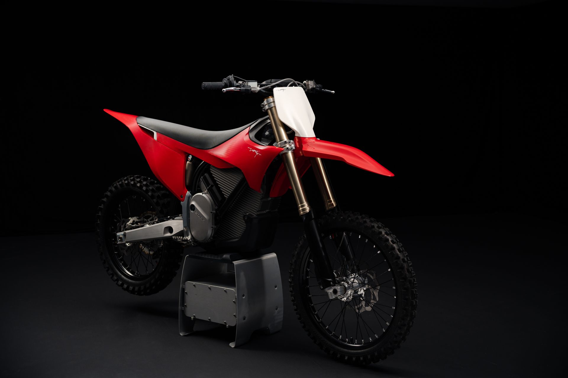 Ein rotes Dirtbike ist auf einem schwarzen Hintergrund geparkt