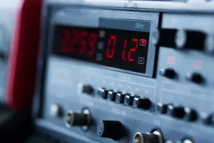 Close-up de equipamento eletrônico com um visor digital vermelho mostrando números e símbolos.