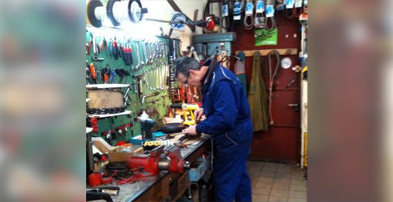 Employé de Jardi'Dep dans l'atelier en pleine opération de réparation.