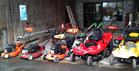 Vue sur quelques modèles de tondeuses exposées dehors.