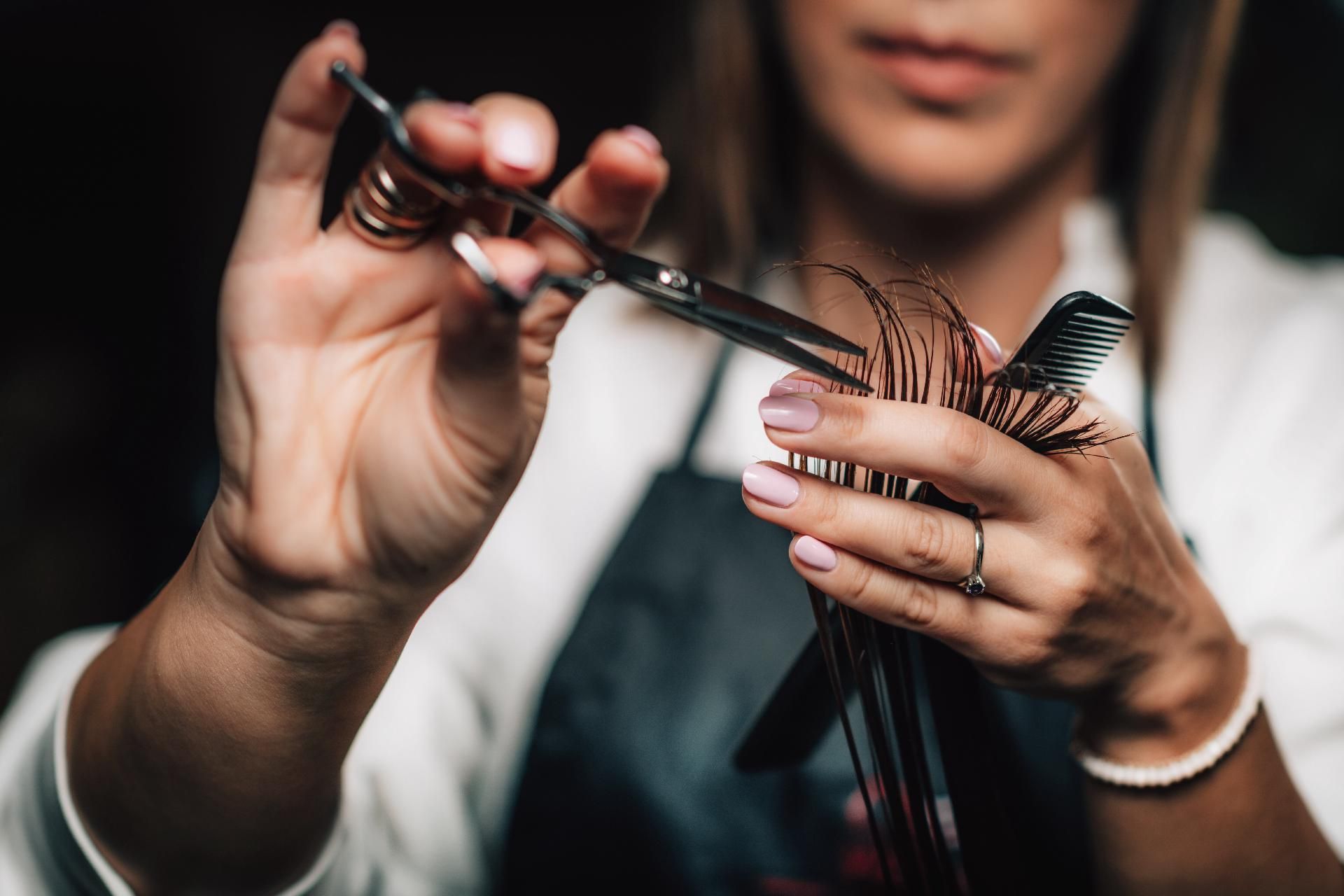 Hände schneiden Haare mit Schere und Kamm, Nahaufnahme in einem Friseursalon