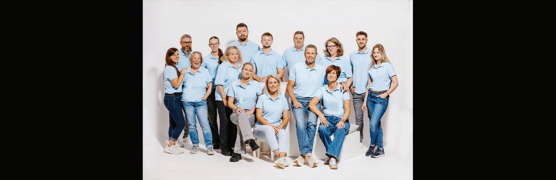 Eine Gruppe von Menschen steht in einer Reihe mit verschränkten Armen
