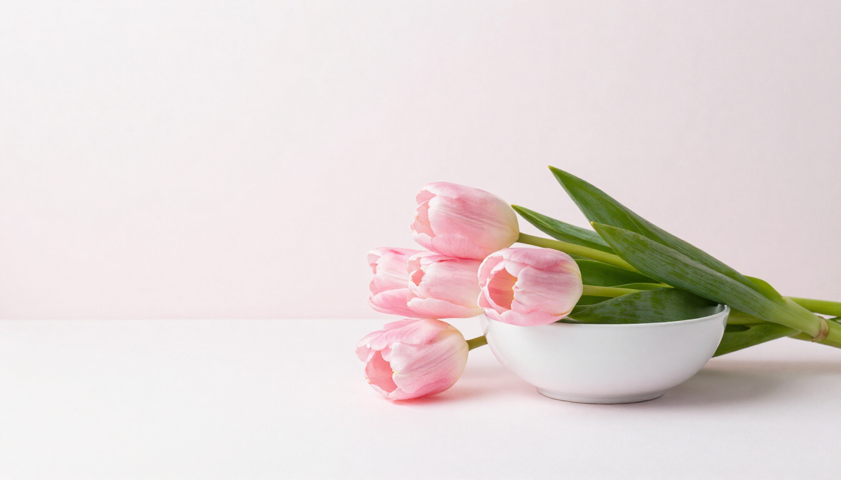 Rosa Tulpen in einer Glasvase auf heller Fläche