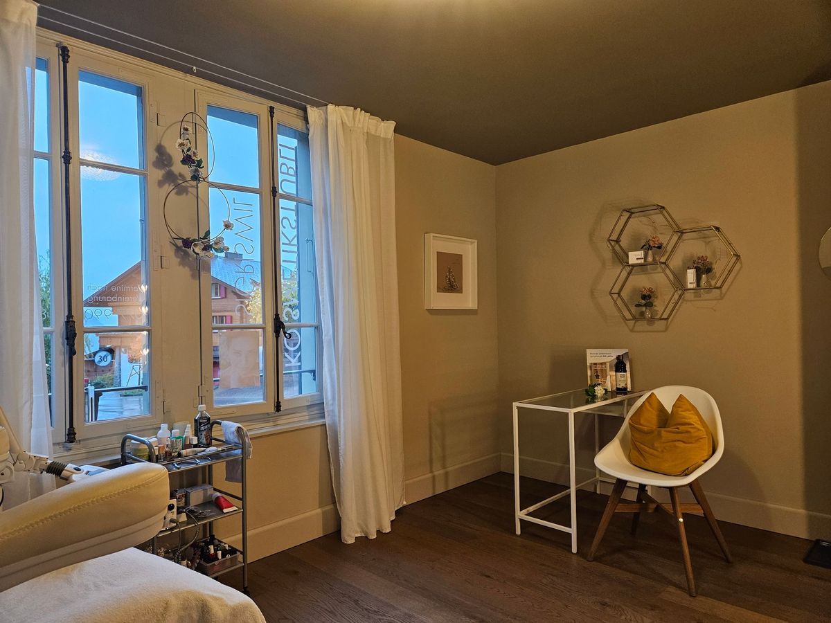 Heller Raum im Kosmetikstübli mit Fenstern, Stuhl und goldenen Wabenregalen