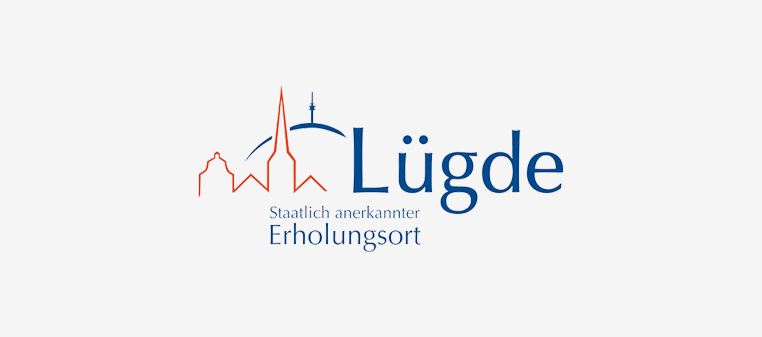 Logo von Lügde, einer Stadt in Deutschland. Zeigt eine rot-blaue Skyline mit dem Stadtnamen in blauer Schrift.