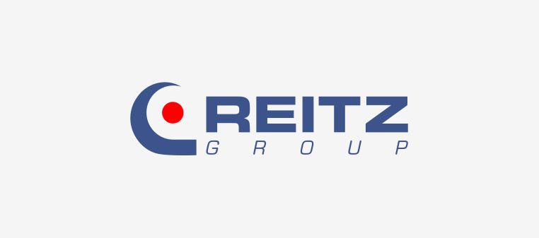 Logo der REITZ Group: blauer Bogen und roter Punkt, mit blauem Text „REITZ GROUP“.