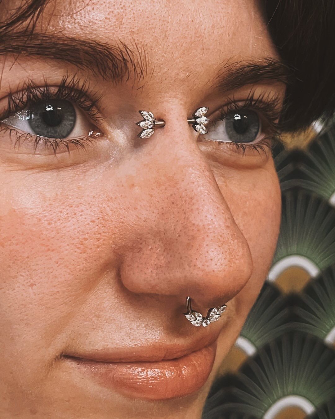 Une femme avec un piercing dans le nez et un entre les deux yeux 