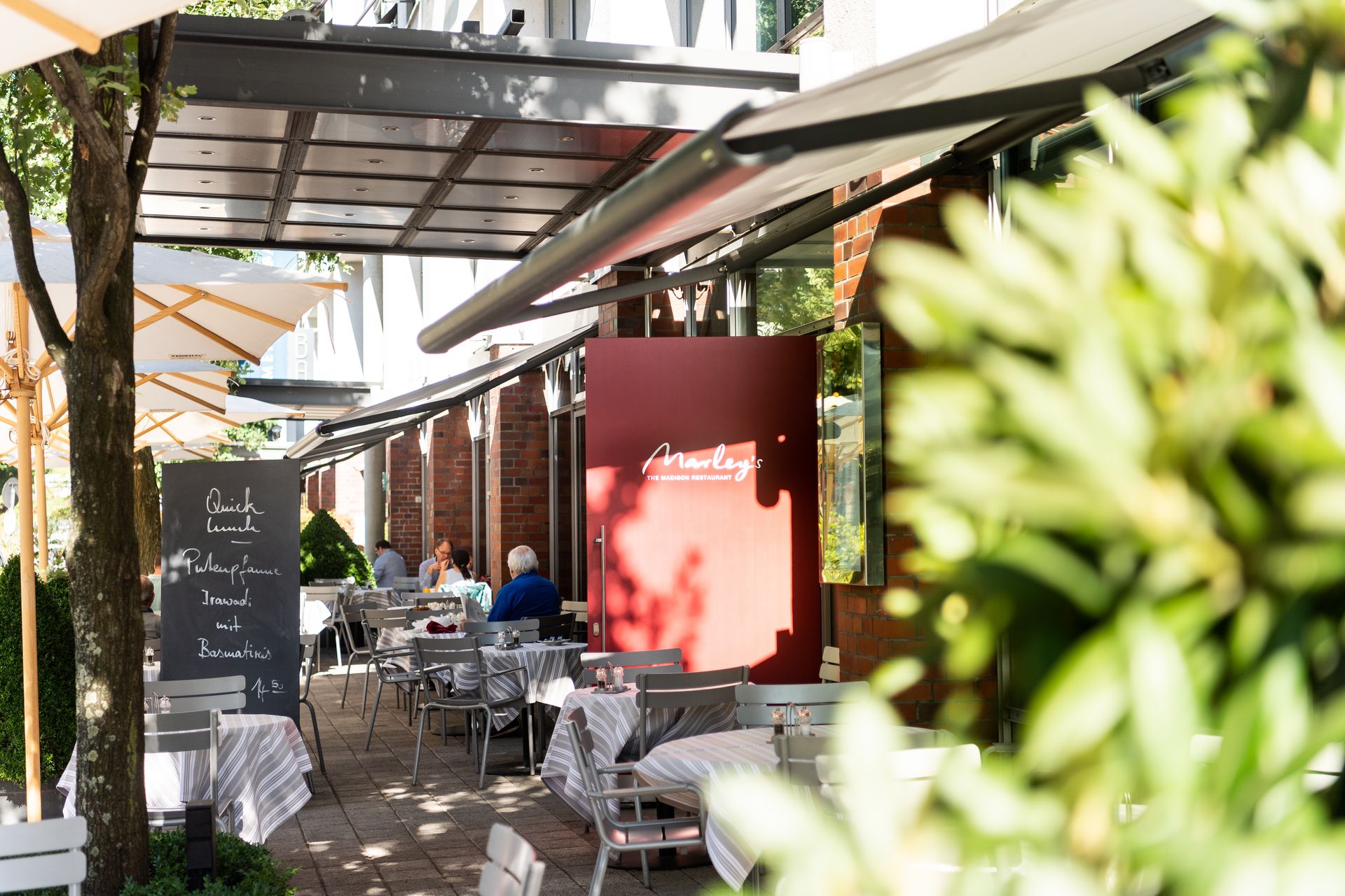 A restaurant with tables and chairs and umbrellas outside