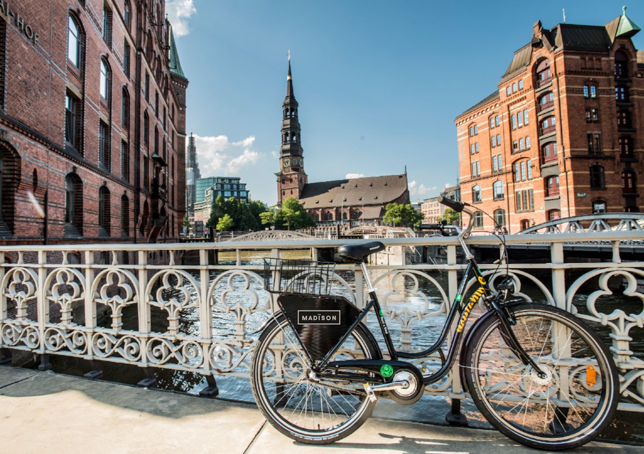 Auf einer Brücke in einer Stadt ist ein Fahrrad abgestellt.