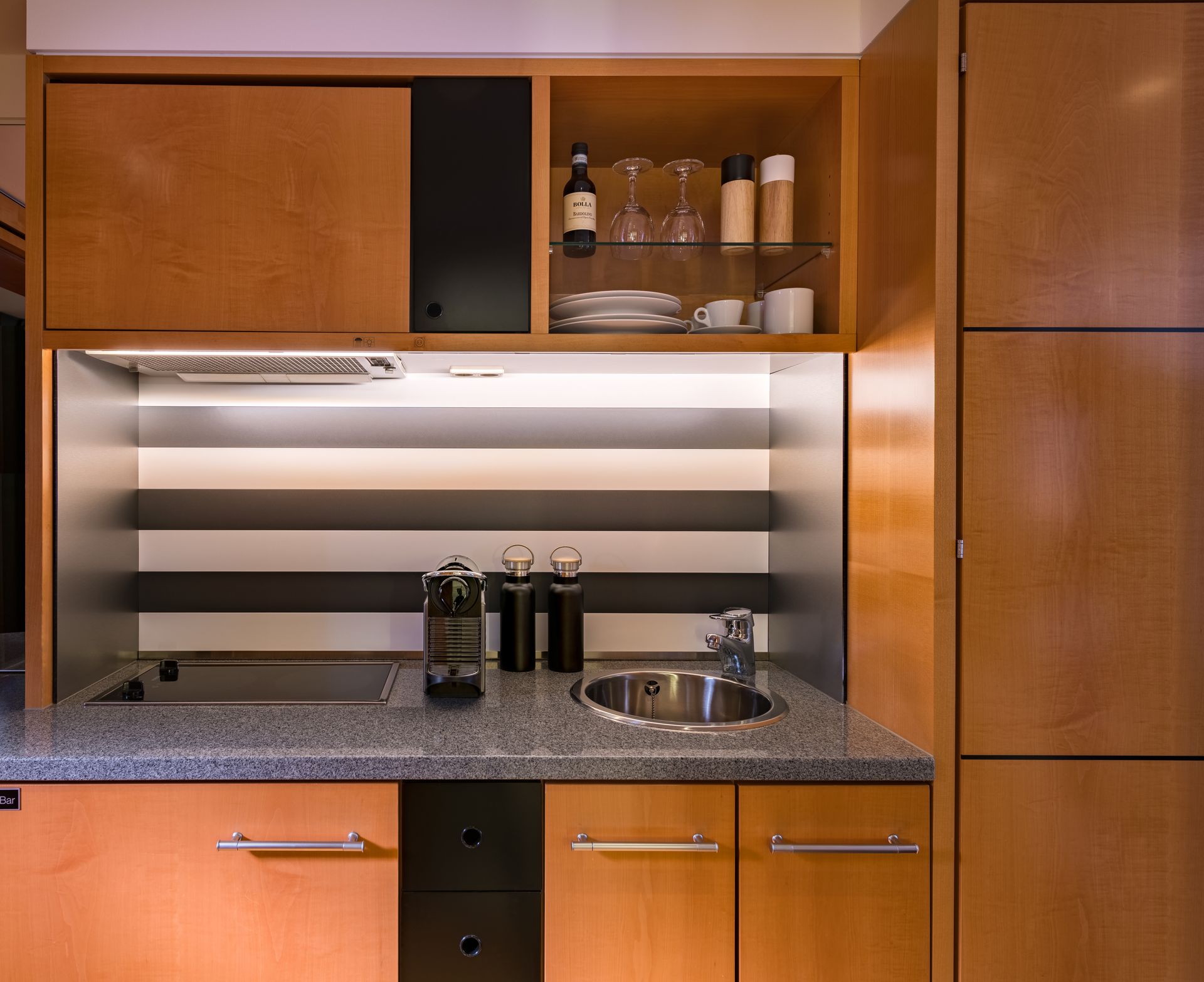 A kitchen with wooden cabinets and a stainless steel sink