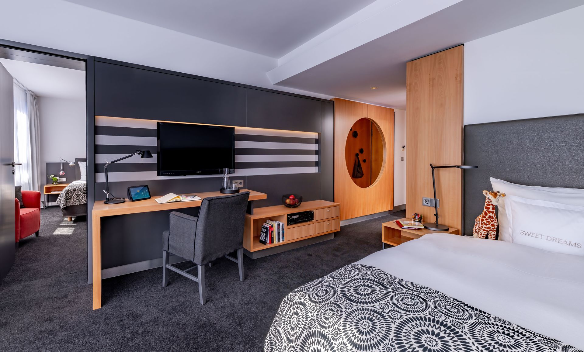 A hotel room with a bed , desk , chair and television.