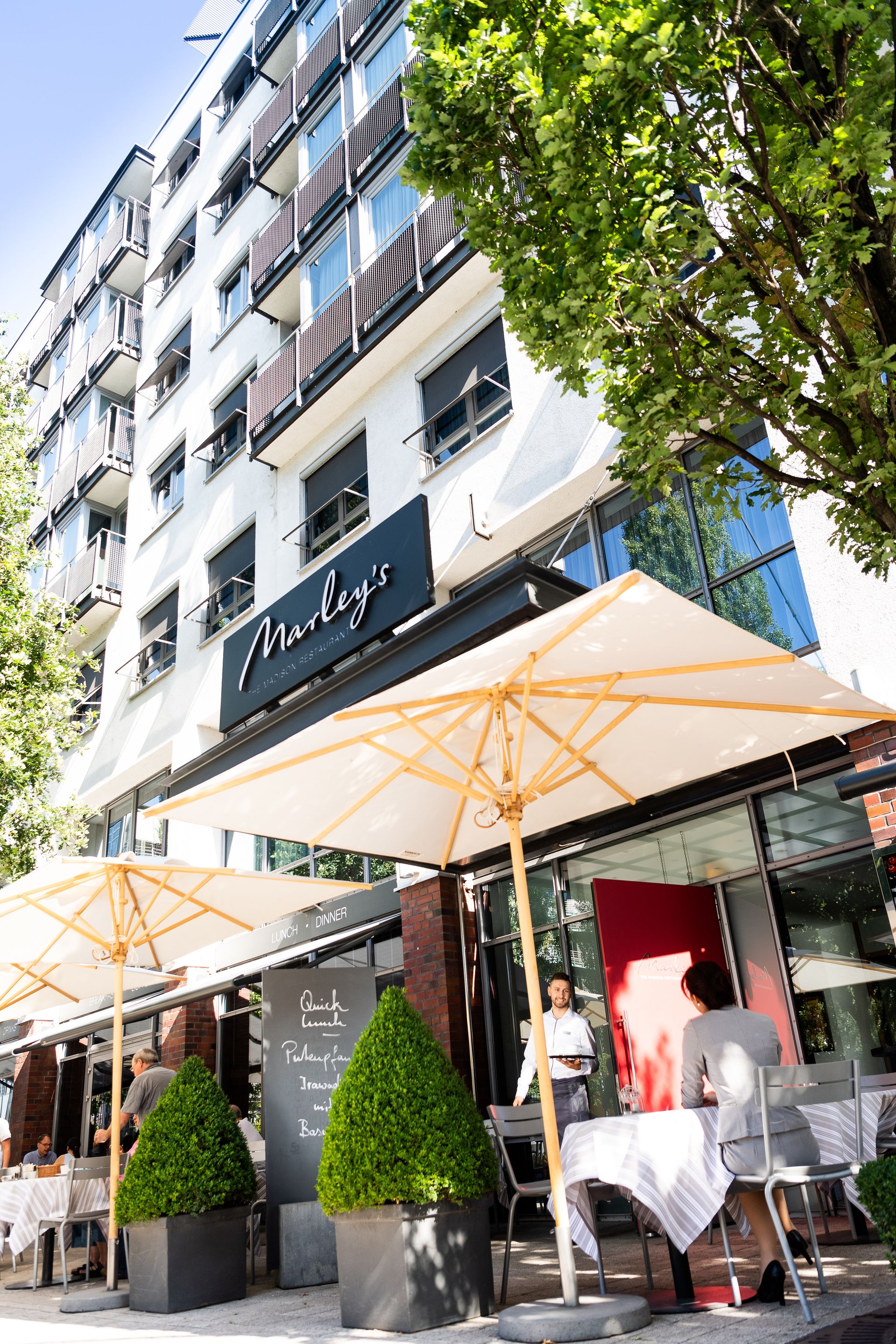 A restaurant with tables and umbrellas outside of it