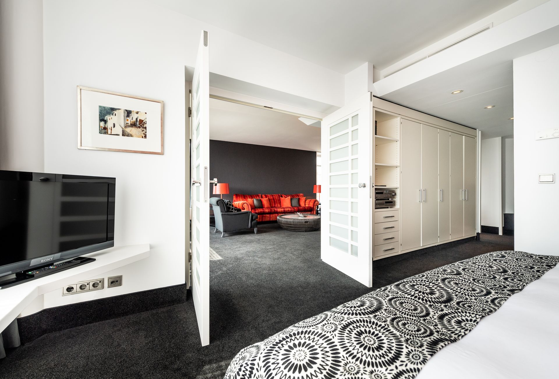 A hotel room with a bed a television and a couch