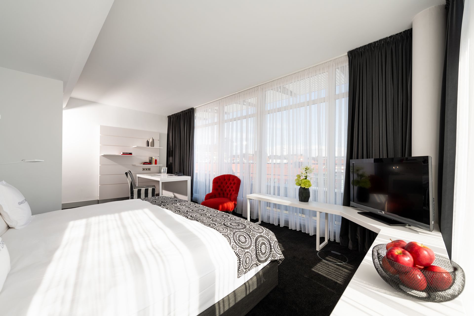 A hotel room with a king size bed and a tv