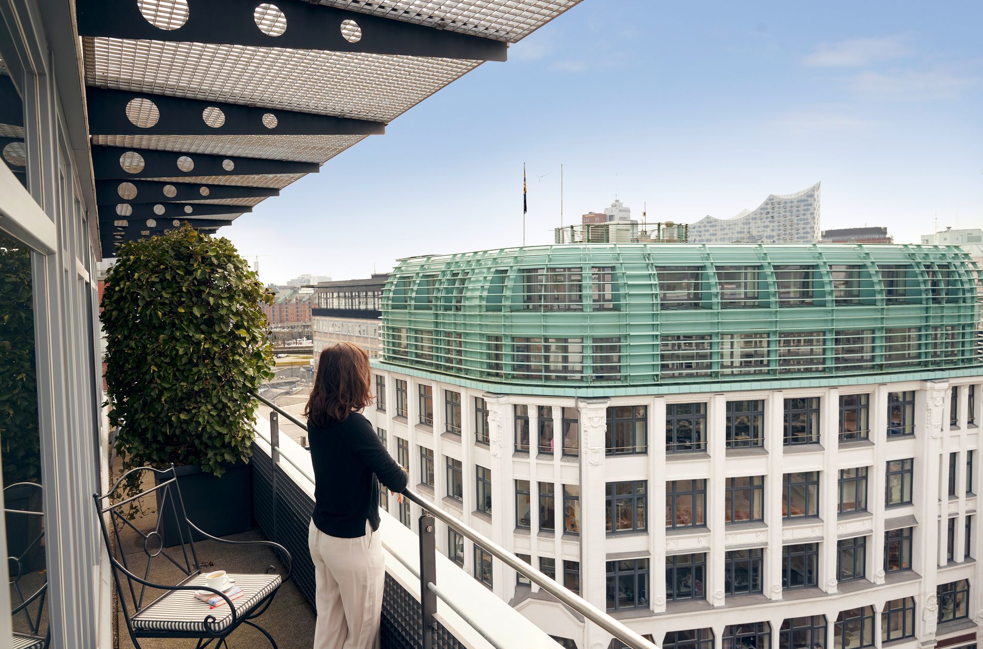 A woman standing on a balcony overlooking a building