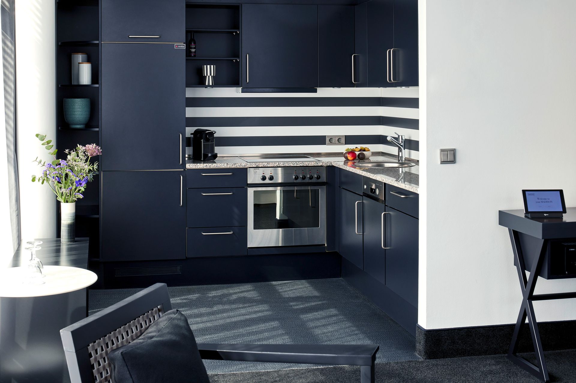 A kitchen with blue cabinets and white stripes on the wall