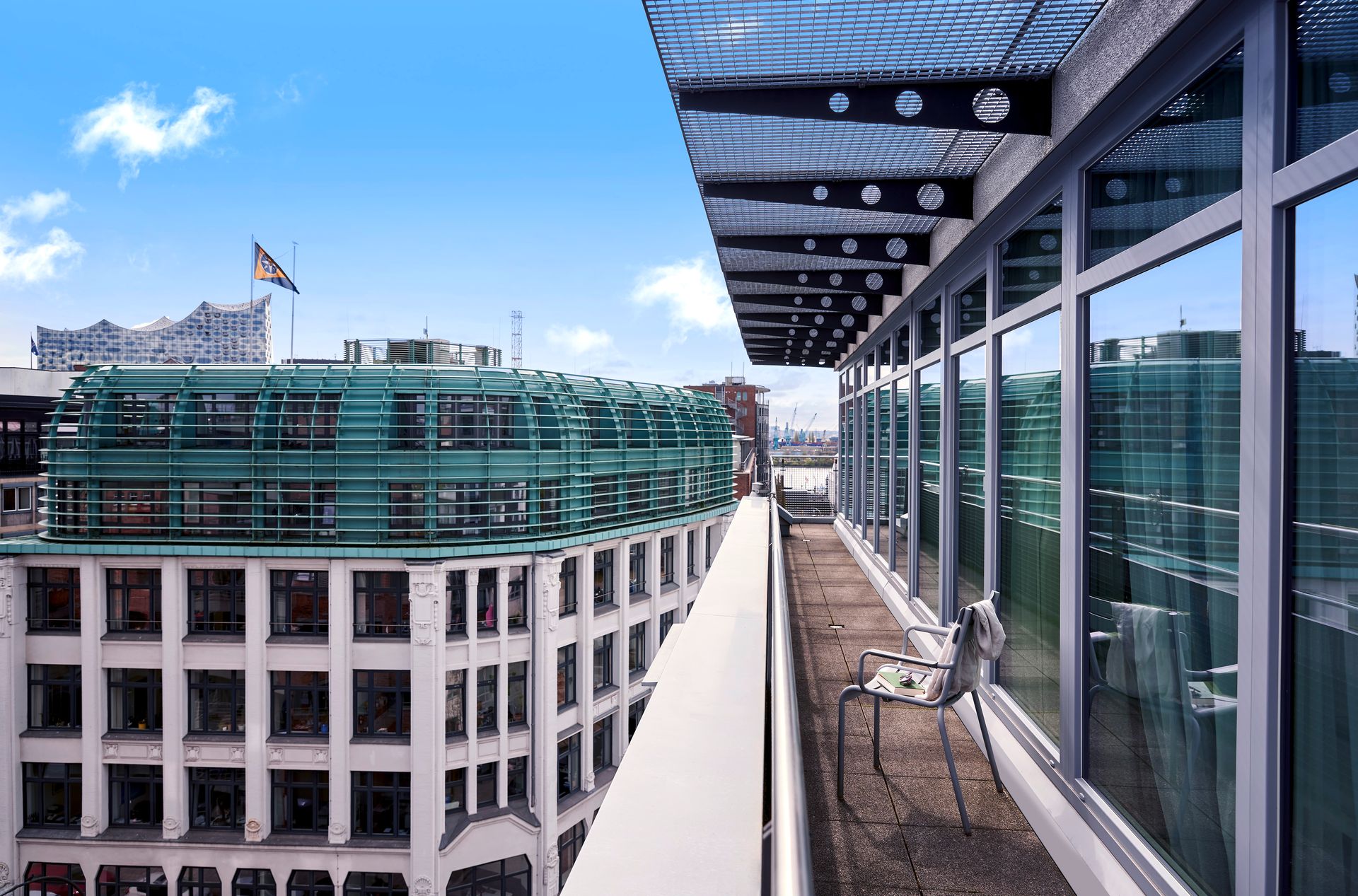 A balcony overlooking a city with a flag on top of a building