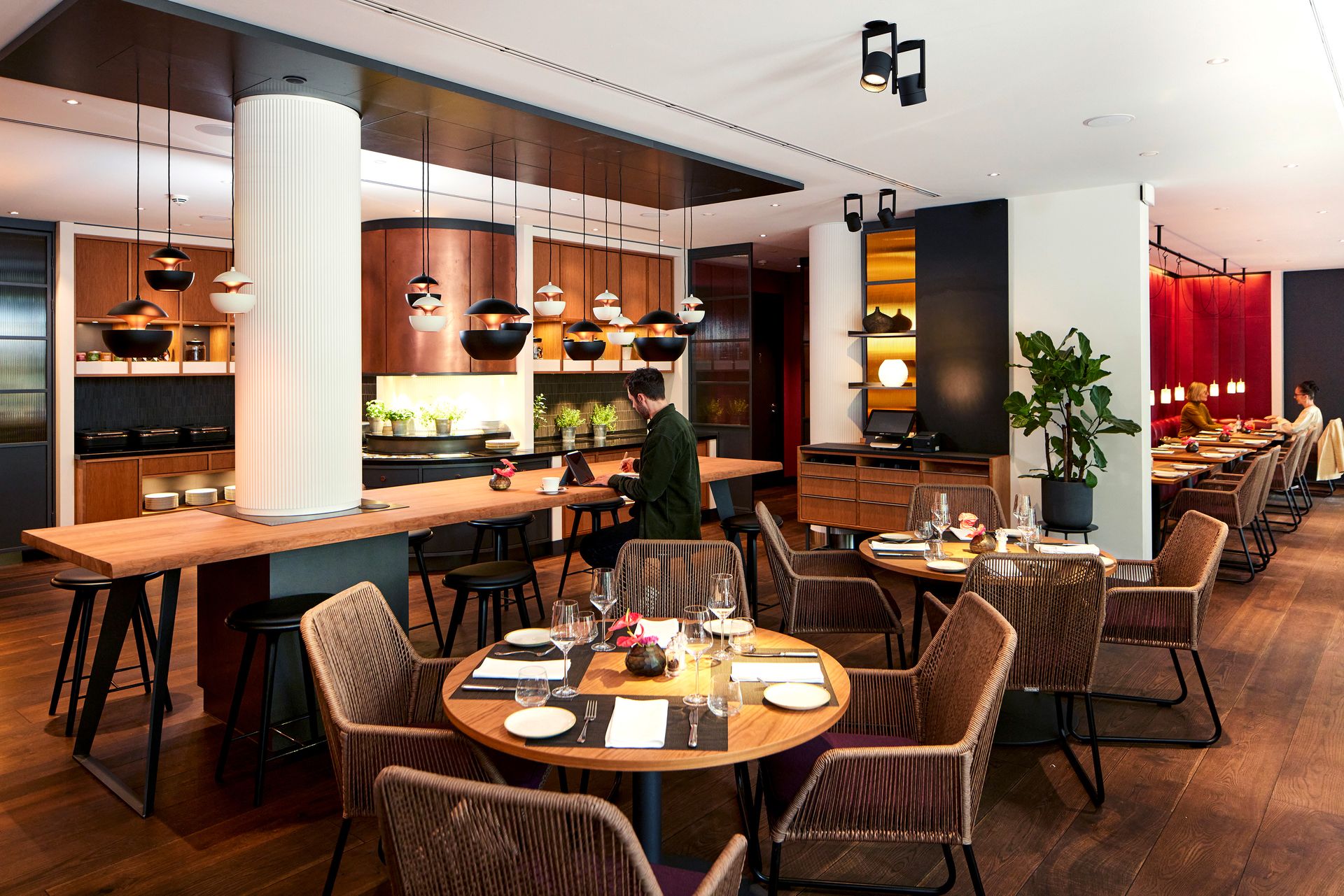 A man is sitting at a table in a restaurant.