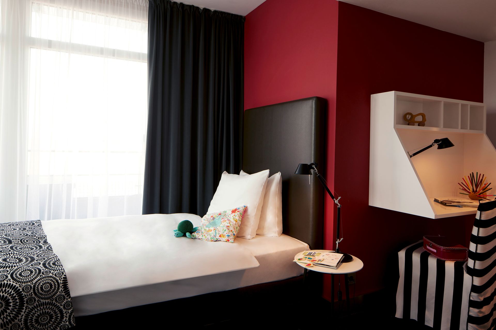 A bedroom with a single bed and a desk.