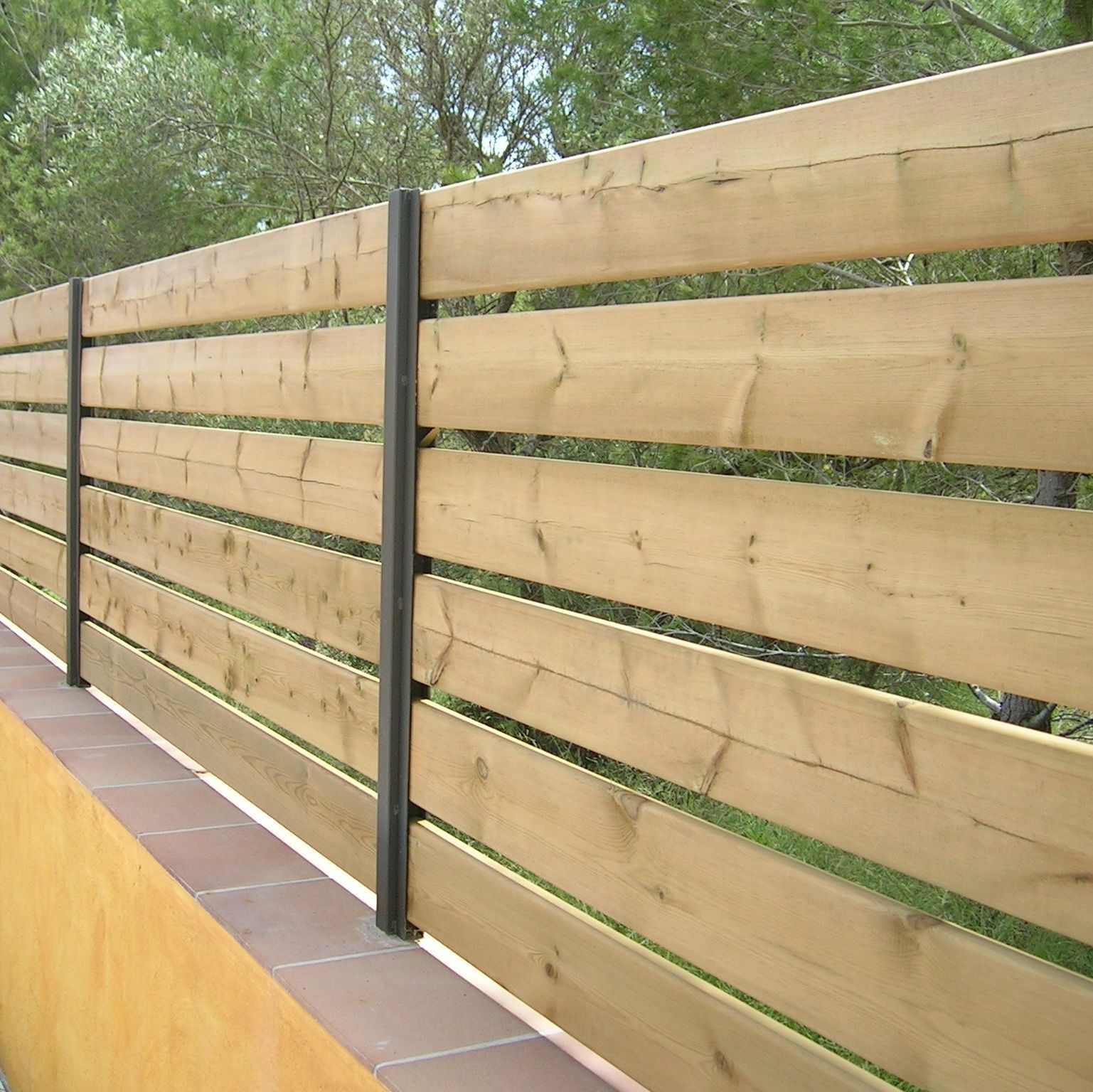 Una valla de madera con árboles al fondo