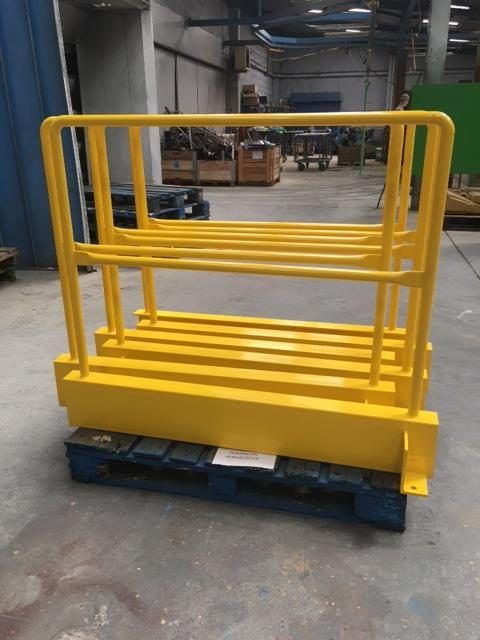 Plateforme de sécurité en métal jaune sur une palette dans un entrepôt industriel.