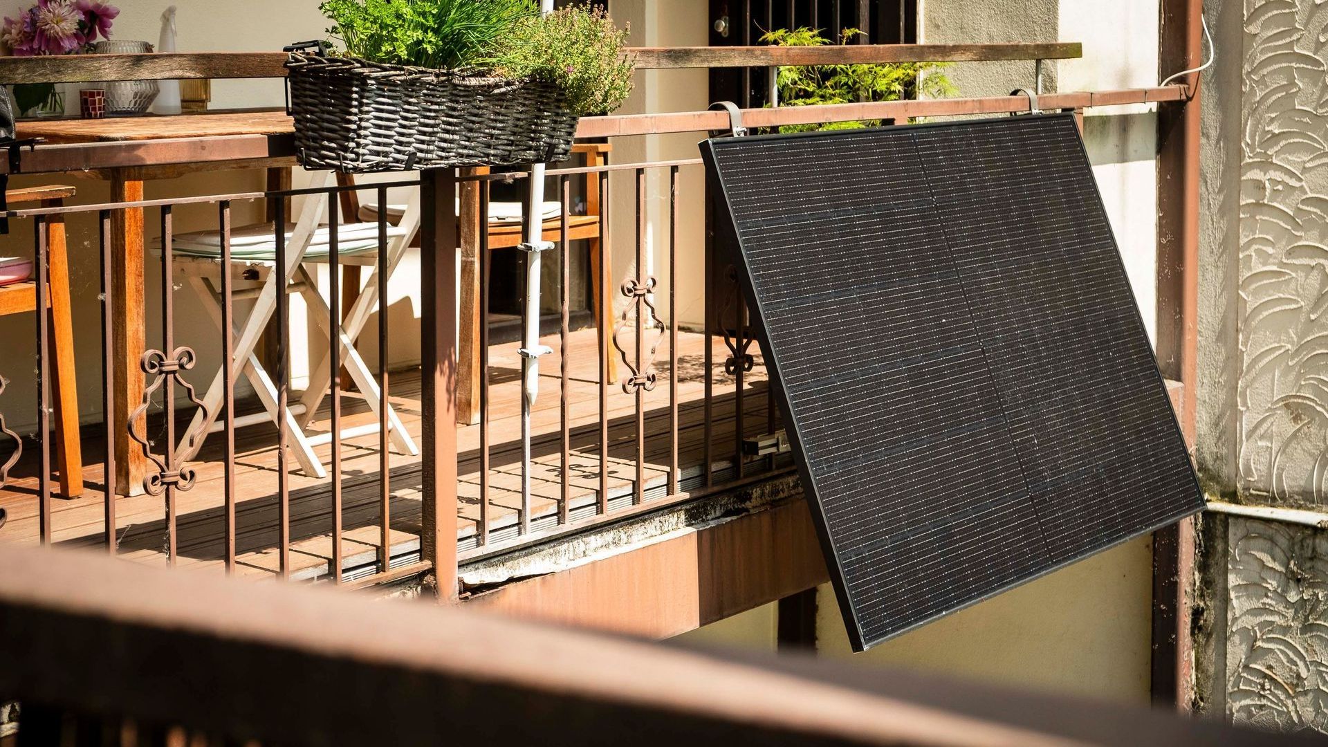 ein Sonnenkollektor hängt an einem Metallgeländer auf einem Balkon