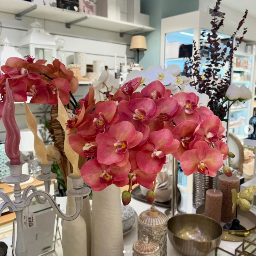 Un ramo de flores rosas en un jarrón sobre una mesa.